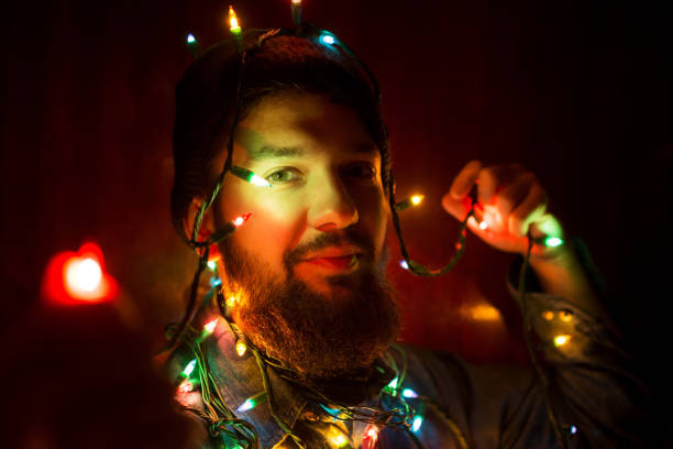 istock Bearded man wrapped in Christmas lights 867383800