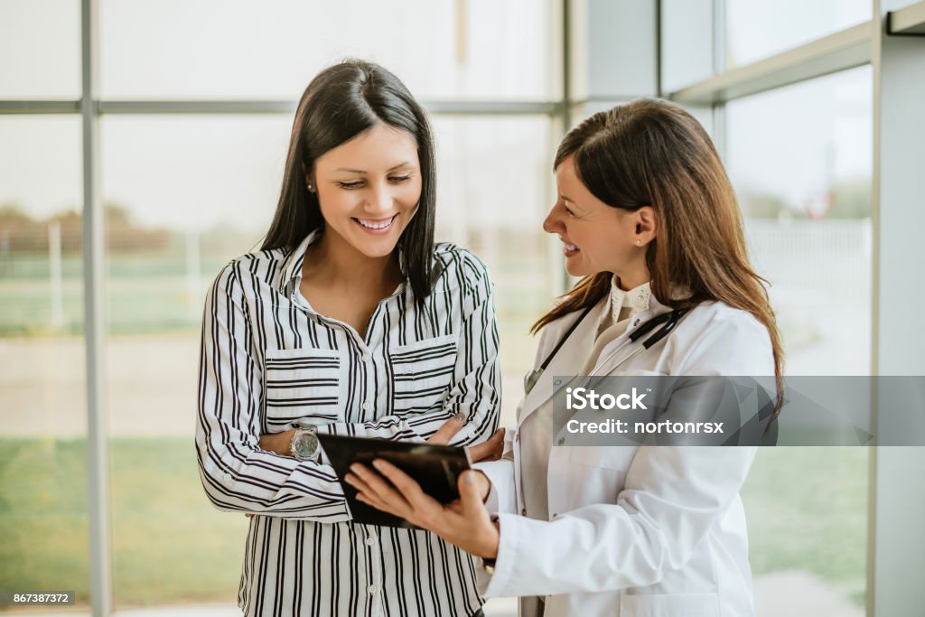 Doctor talking and laughing with her female patient. Doctor Stock Photo