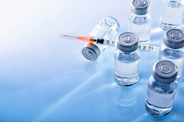 Vials and syringe on blue table top elevated Vials with medication and syringe on blue methacrylate table. Horizontal composition. Top elevated view. medical injection stock pictures, royalty-free photos & images