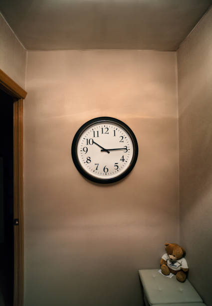 istock Wall clock on a brown wall, ajar door 867398668