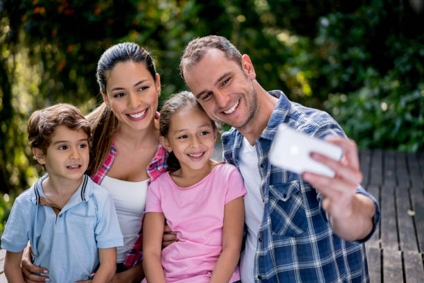 istock Happy family outdoors taking a selfie with a cell phone 867401902