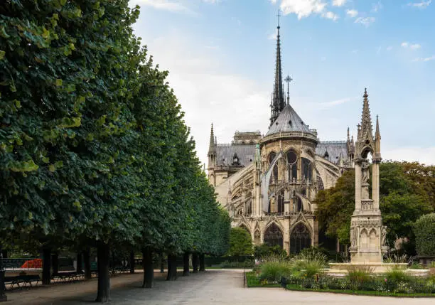 View of the East-end of the Notre-Dame de Paris cathedral in the morning with the fountain of the Virgin in the foreground.