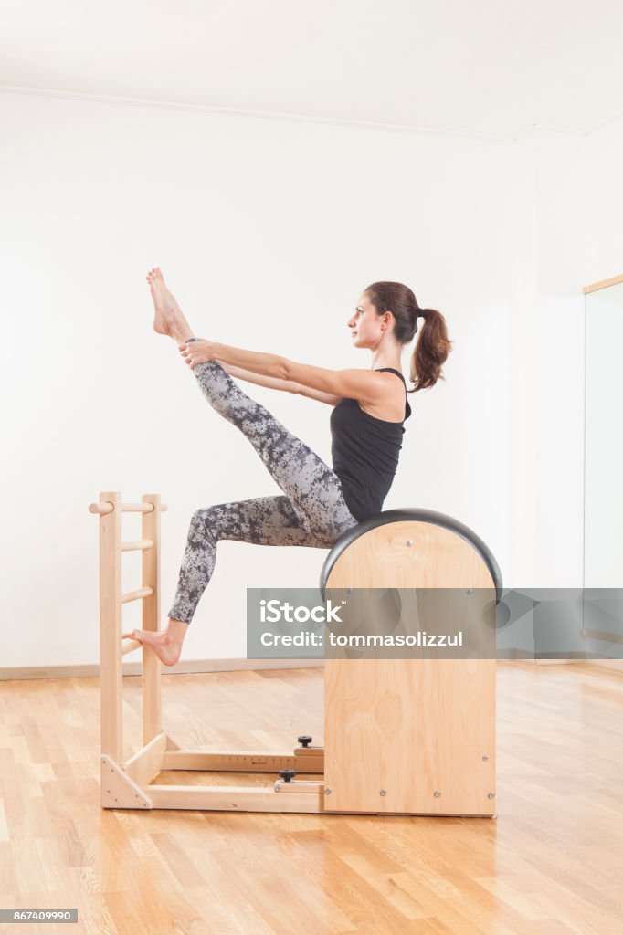 Beautiful Woman Performing Pilates Exercise Training On Barrel