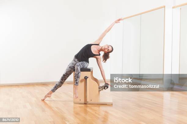 Pilates Lesson On Barrel Personal Trainer Coaching Young Beautiful Woman Stock Photo - Download Image Now