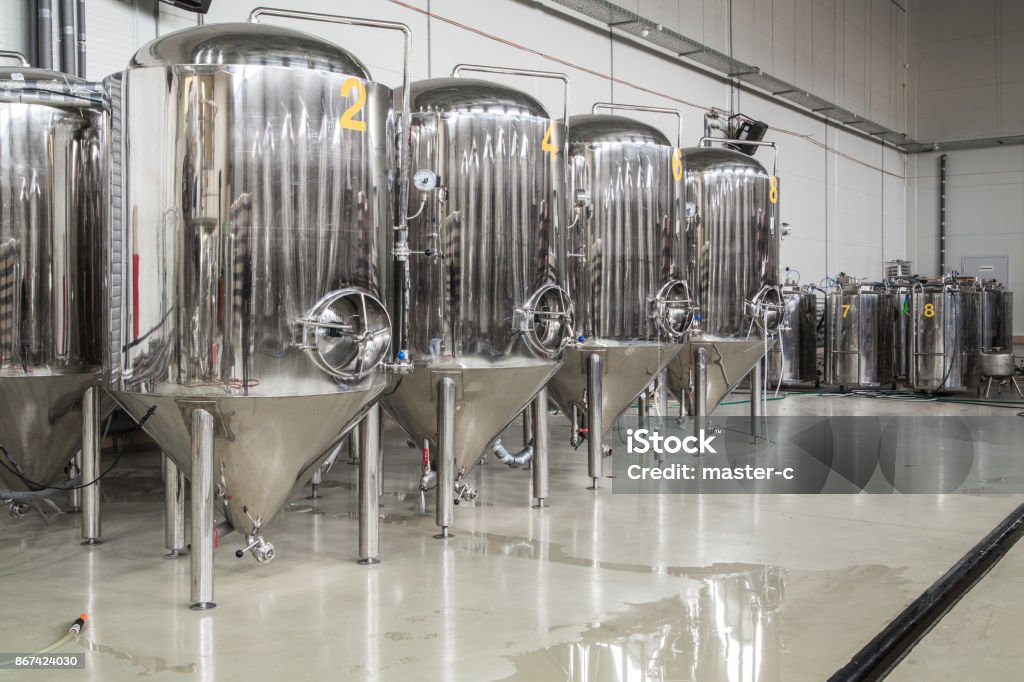Modern brewery with stainless steel tanks Brewery. Modern beer plant with brewering kettles, tubes and tanks made of stainless steel Storage Tank Stock Photo
