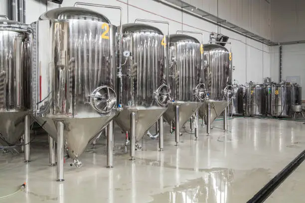 Brewery. Modern beer plant with brewering kettles, tubes and tanks made of stainless steel