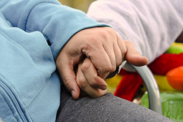 A couple sitting in a chair holding hands while camping A couple sitting in a chair holding hands while camping. clingy girlfriend stock pictures, royalty-free photos & images