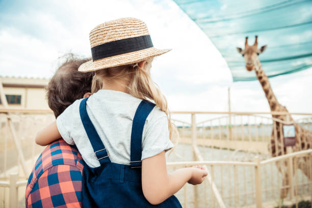 istock family looking at giraffe in zoo 867431890
