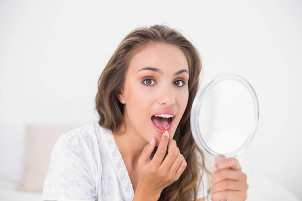 istock Attractive brunette opening mouth and holding mirror 867437556