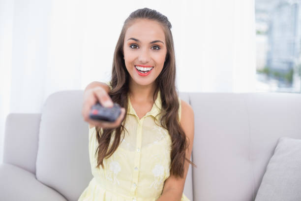 istock Excited pretty brunette holding remote 867442300