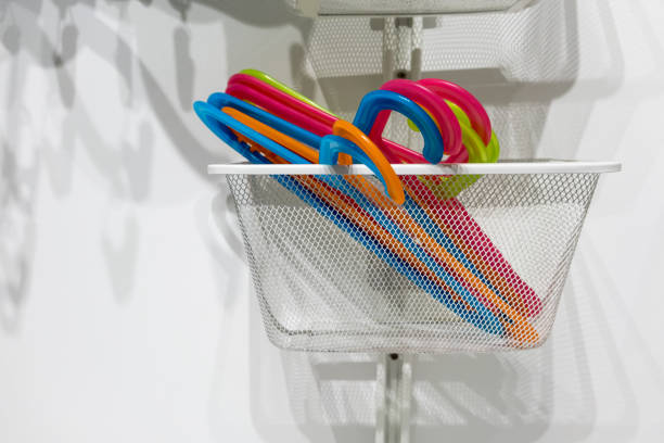 istock Colorful plastic hanger in white metal basket hanging against white wall. 867442500