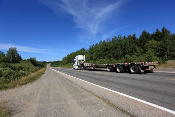istock Semi truck on highway with flat bed trailer 867456450
