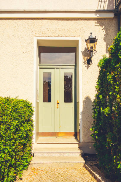 istock green entrance door on white facade 867458970
