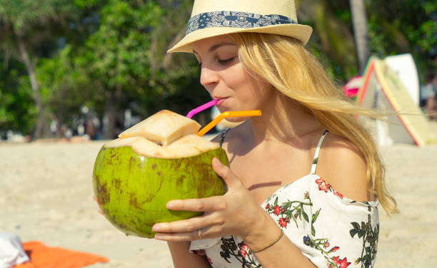 istock Attractive woman drinking coconut 867463566