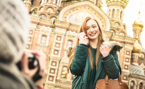 felizes namoradas tomando viagens de inverno foto na igreja "savior on spilled blood", em são petersburgo - conceito de wanderlust amizade com jovens garotas se divertindo juntos tomar café ao ar livre - st petersburg russia russian culture church of the resurrection of christ - fotografias e filmes do acervo