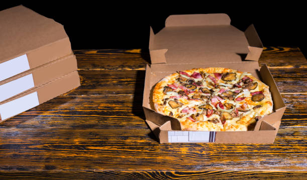istock Pizza with ham, mushrooms, onion and pickles in a box 867473436