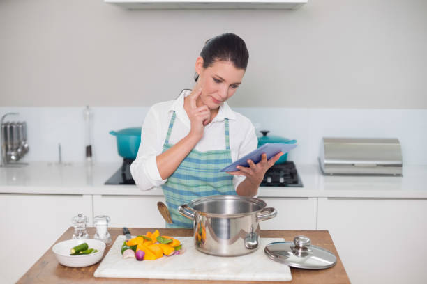 istock Focused gorgeous woman wearing apron using tablet 867474196