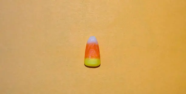 Photo of Candy corn on orange background.