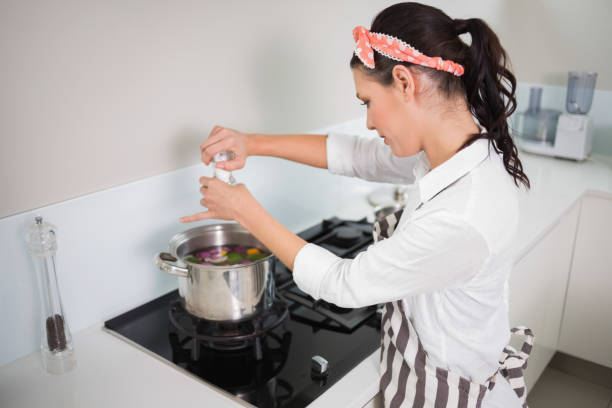 istock Focused gorgeous cook putting salt on vegetables 867477612