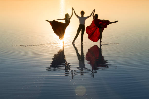 young group of dancer dancing on the lake in the evening