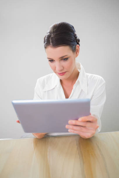 istock Focused businesswoman working on tablet pc 867483902