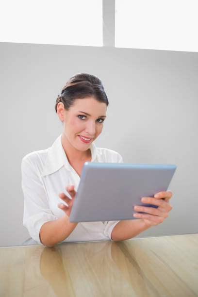 istock Smiling pretty businesswoman working on tablet pc 867483920