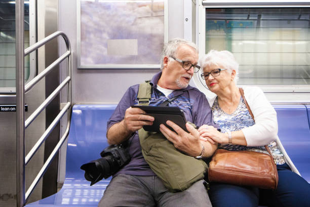istock Senior couple look at information on tablet while in transit in subway 867486950