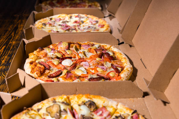 close up of tasty pizzas with variety of toppings and cheese in cardboard take out boxes - italian cuisine minced meat tomato herb imagens e fotografias de stock
