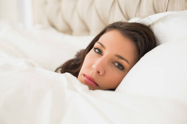 istock Relaxed pretty brown haired woman lying in her bed 867491612