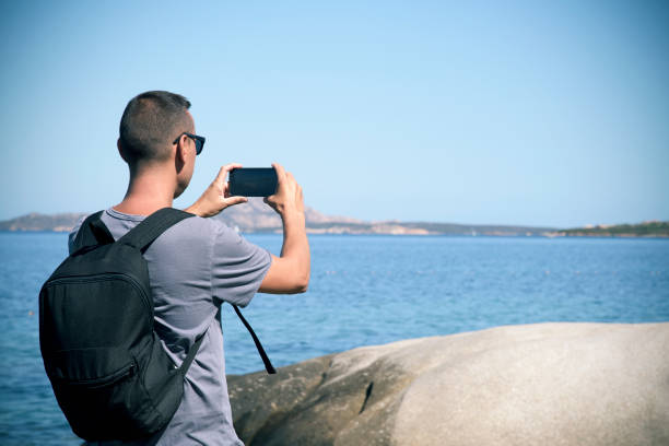 istock young man taking a picture in Sardinia, Italy 867491672