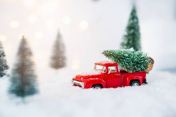 istock Red toy pickup car carrying Christmas tree 867502932