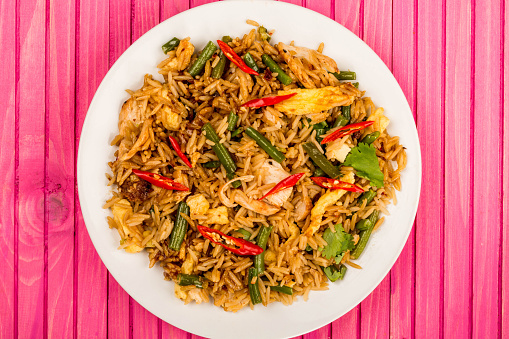 Indonesian Style Nasi Goreng Chicken and Rice Meal On A Pink Wooden Background