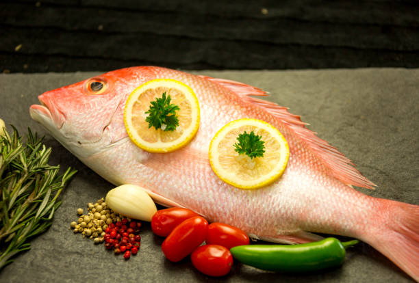 istock Red Snapper on a grill with seasoning and vegetable 867516280