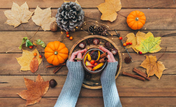 istock Hands holding Delicious cup of tea on a rustic wooden table. Autumn composition 867516568