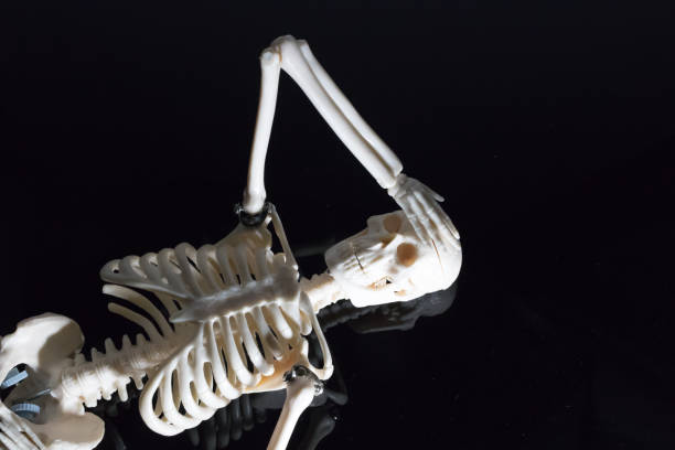 istock The worried skeleton laying on the black reflection plate 867531266