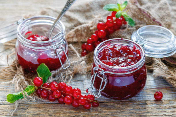 istock Old table with red currants and a jar of homemade jam. 867550628