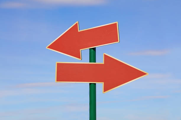 istock Road sign with two red arrows over blue sky 867557380