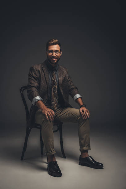 istock Smiling man in suit sitting on chair 867560018