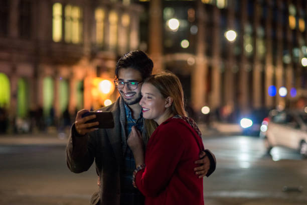 istock Young couple looking social networks at night 867560396