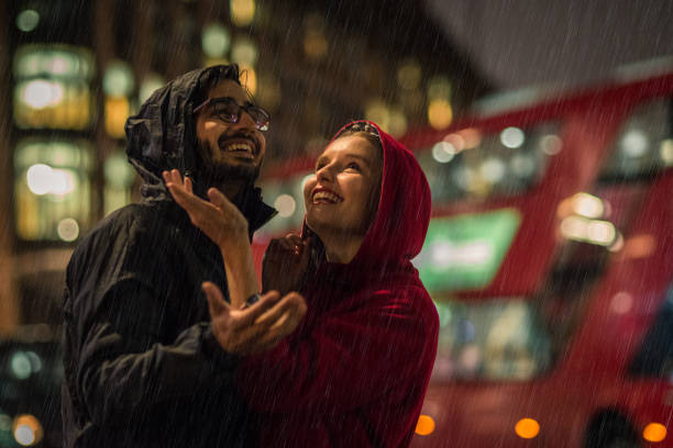 junges paar im regen zu genießen - london in the rain stock-fotos und bilder