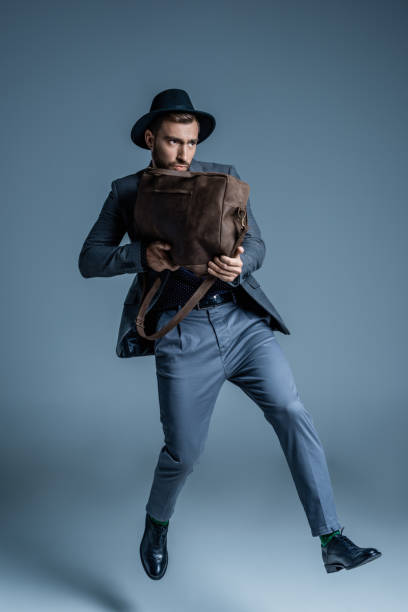 istock man in suit holding leather bag 867563114