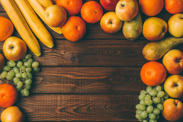 istock Different fruits as frame on rustic wooden background 867566374