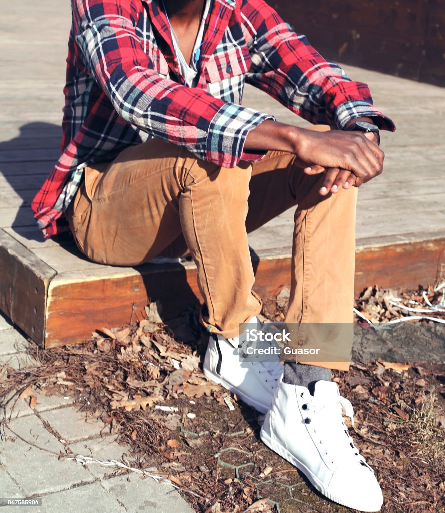Fashion Man In A Plaid Red Shirt And Casual Sneakers Sitting In The City  Stock Photo - Download Image Now - iStock