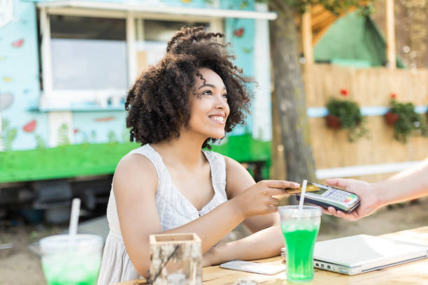 istock Woman drinking cocktail and using credit card 867612546