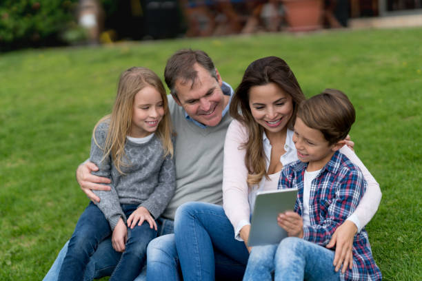istock Happy family outdoors looking at a tablet computer 867612642
