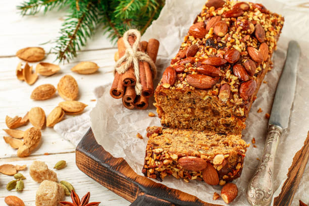 istock Festive Homemade Holiday Fruitcake with Nuts, Fruit and spices. Almonds, cinnamon, star anise, cardamom on the table. Christmas. New year. Selective focus 867612708