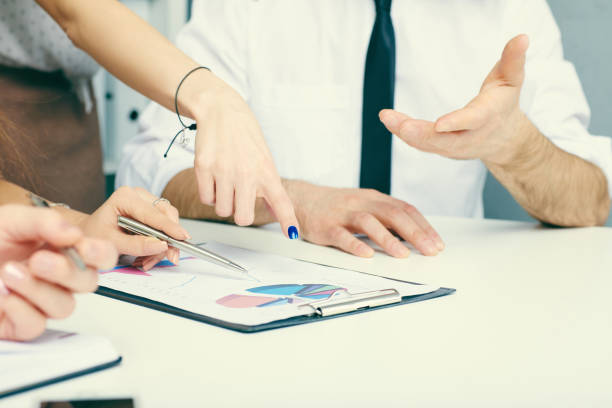 istock Group of business people looking at the clipboard with graphics. 867622706
