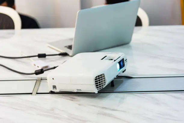 Photo of projector connected to Laptop on for presentation in a meeting room