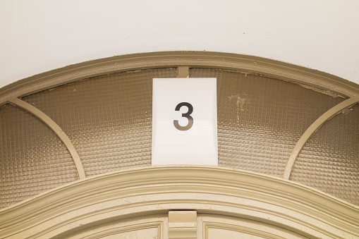 number 3 door sign on old facade