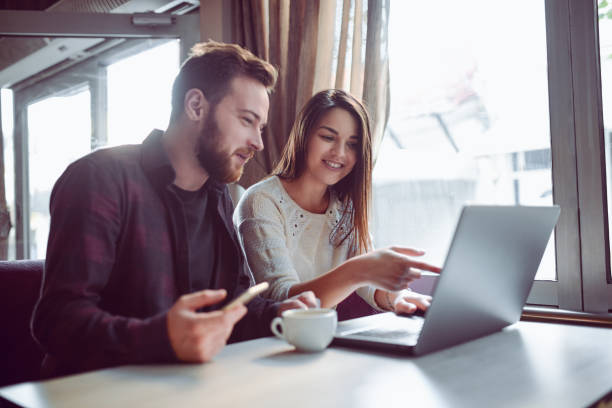 Smiling Couple Drinking Coffee and Making Video Conference in the Morning